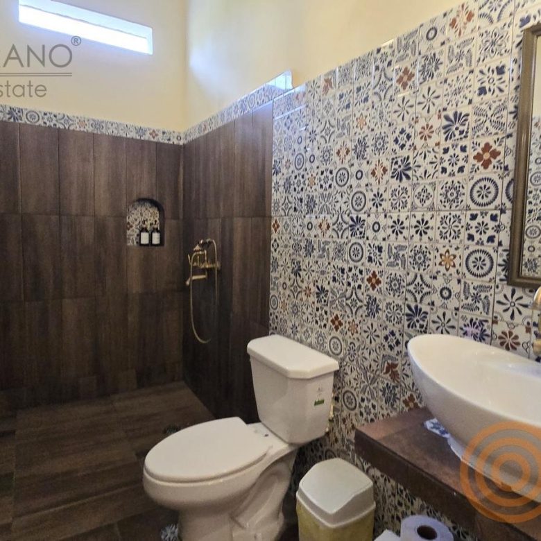 Baño con tina y regadera con azulejo decorado