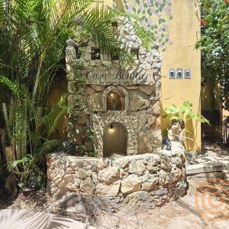 Fuente de piedra entre plantas en el jardín