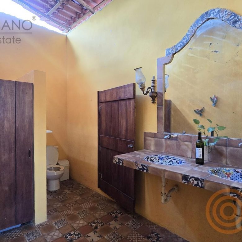 Baño común con lavabo de talavera y puertas de madera