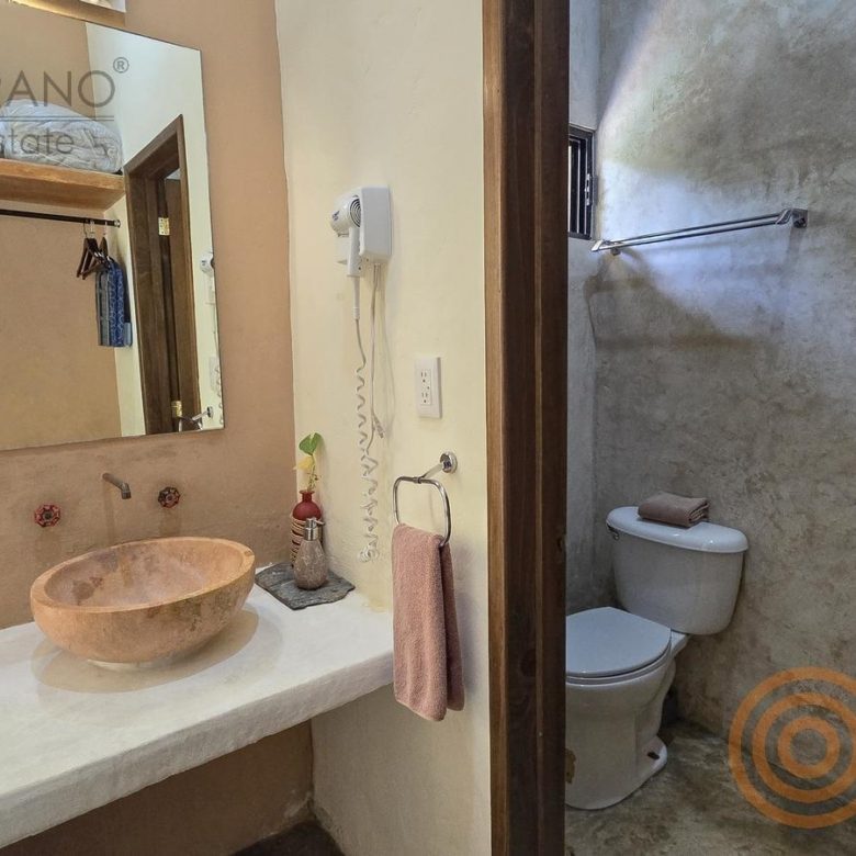 Baño con lavabo de piedra en el hotel boutique de Sisal