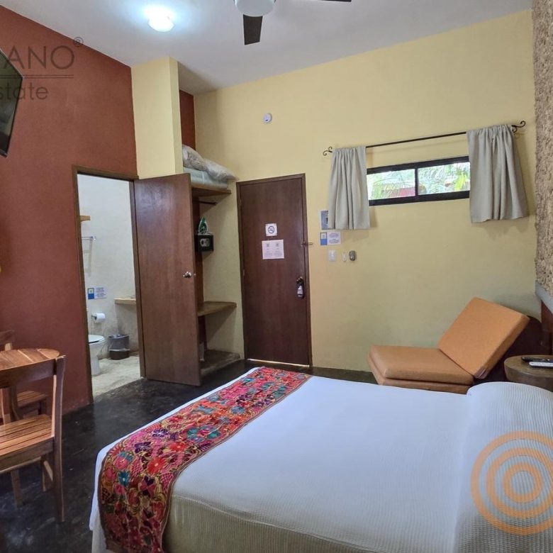 Habitación con muro de piedra y textil artesanal en el hotel