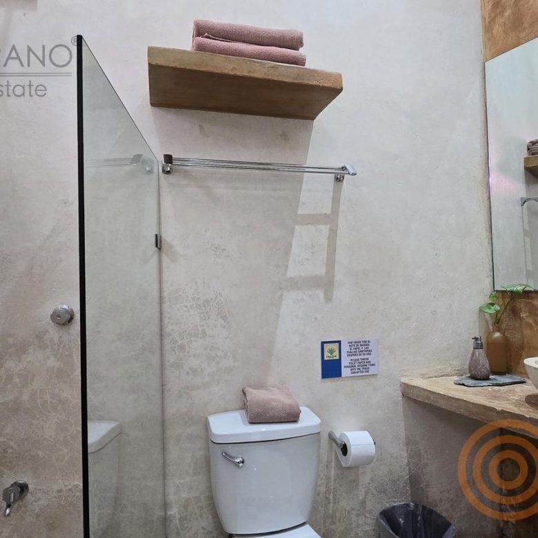 Baño con regadera de cristal en una habitación del hotel