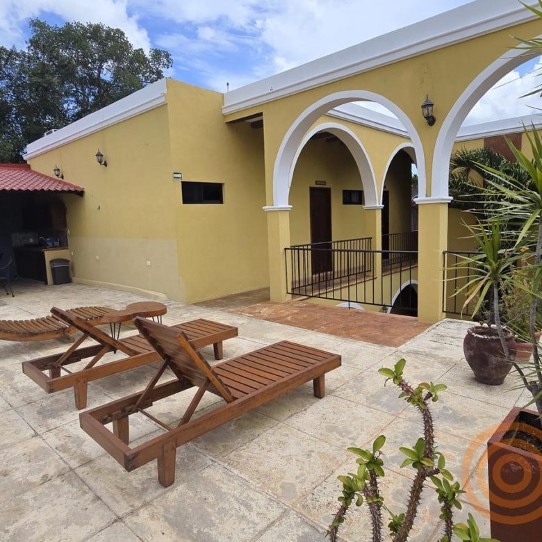 Terraza con camastros y arcos coloniales del hotel en venta