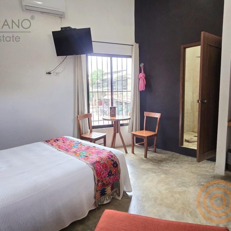 Habitación con cama, TV y ventana a la calle en el hotel