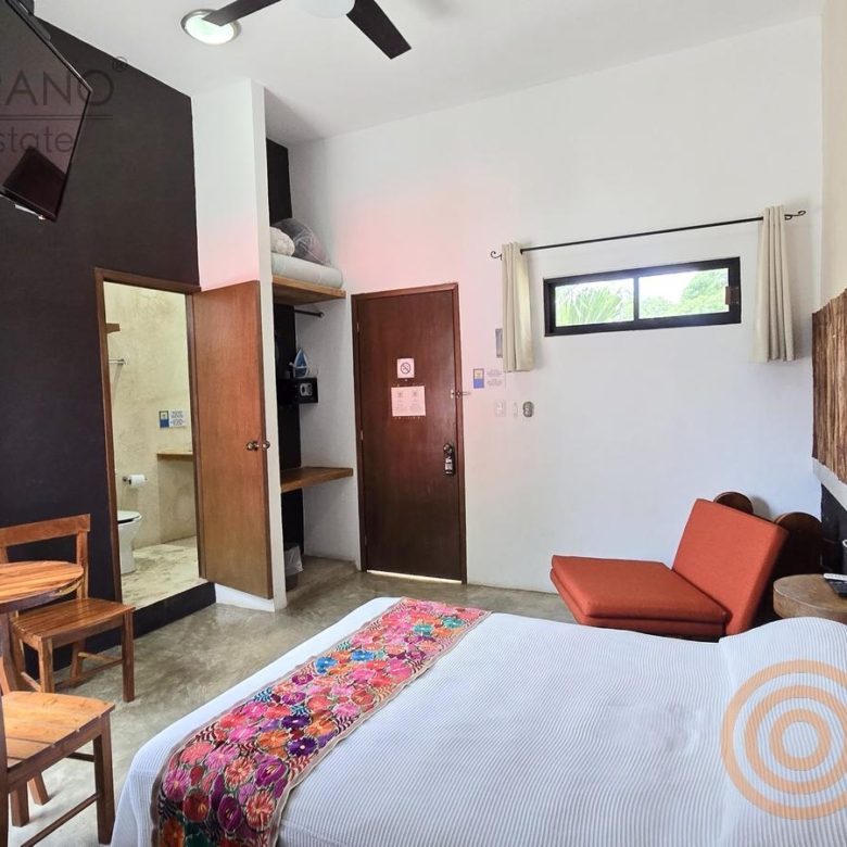 Habitación con muro de madera y sillón en el hotel boutique