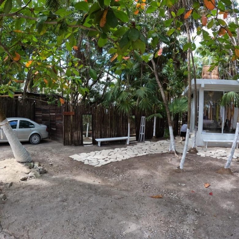 Terreno con andador de piedra, banca y pérgola blanca