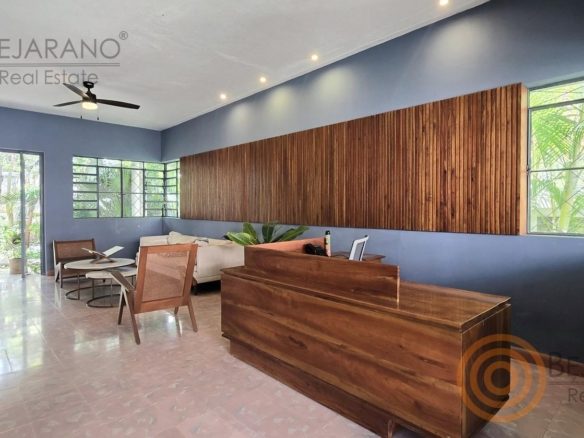 Recepción con mostrador de madera y ventanales al jardín