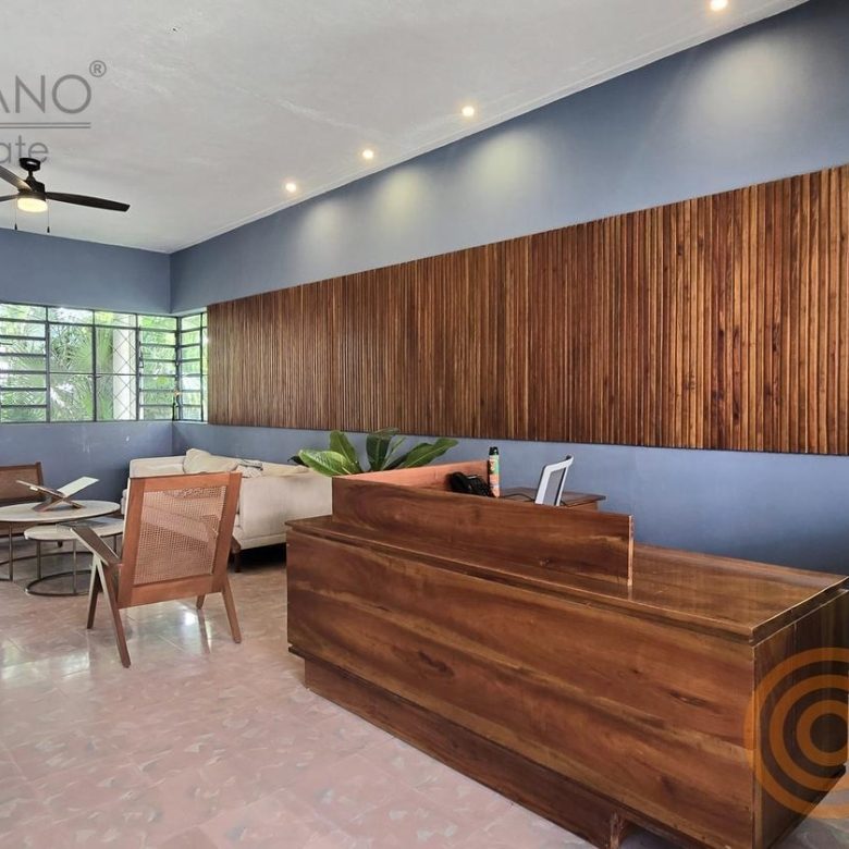 Recepción con mostrador de madera y ventanales al jardín