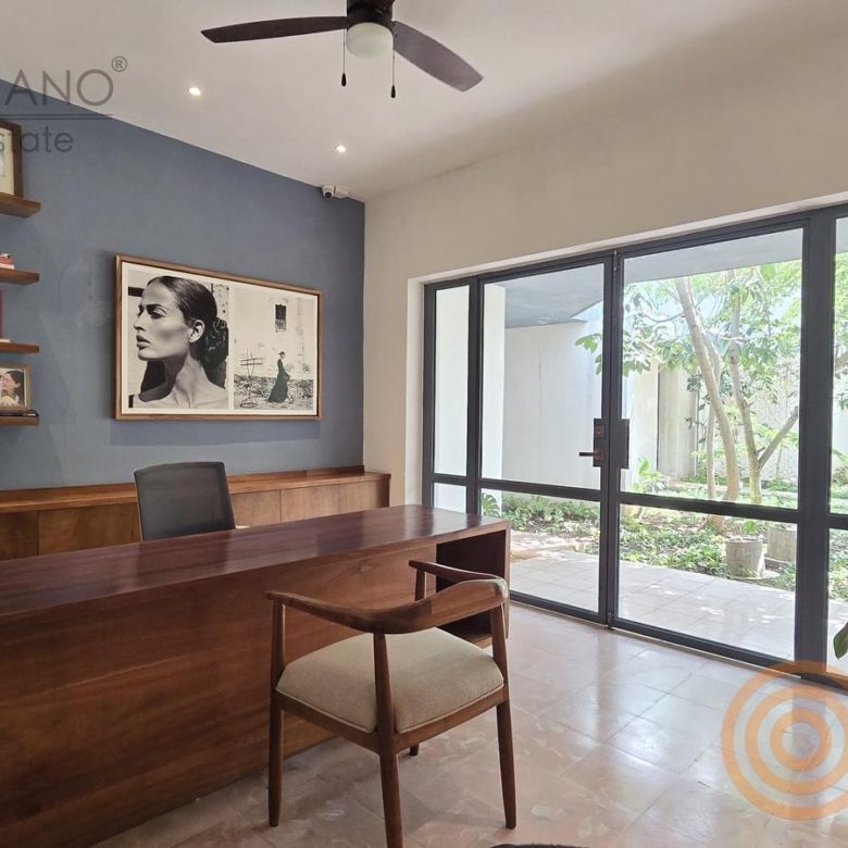 Despacho ejecutivo con escritorio de madera y ventanal al jardín