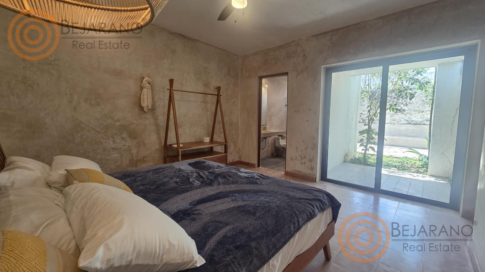 bre-ro-snjuan-27 Habitación amueblada con cama, colgador de madera y puerta al jardín