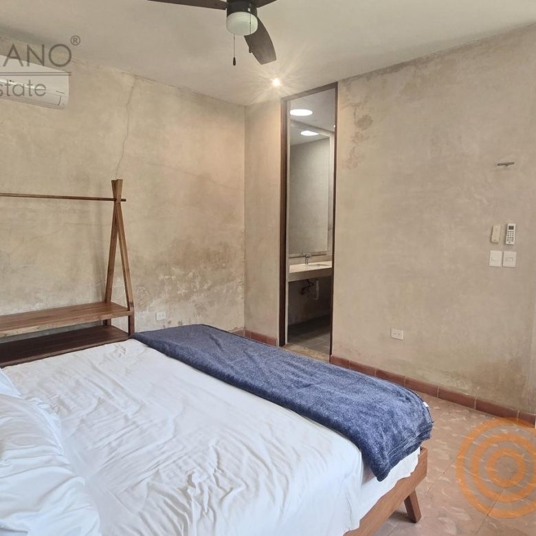 Habitación con cama, aire acondicionado y baño al fondo