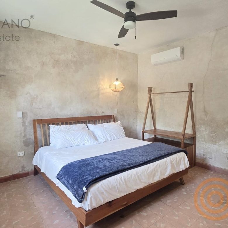 Habitación con cama y muro de acabado rústico