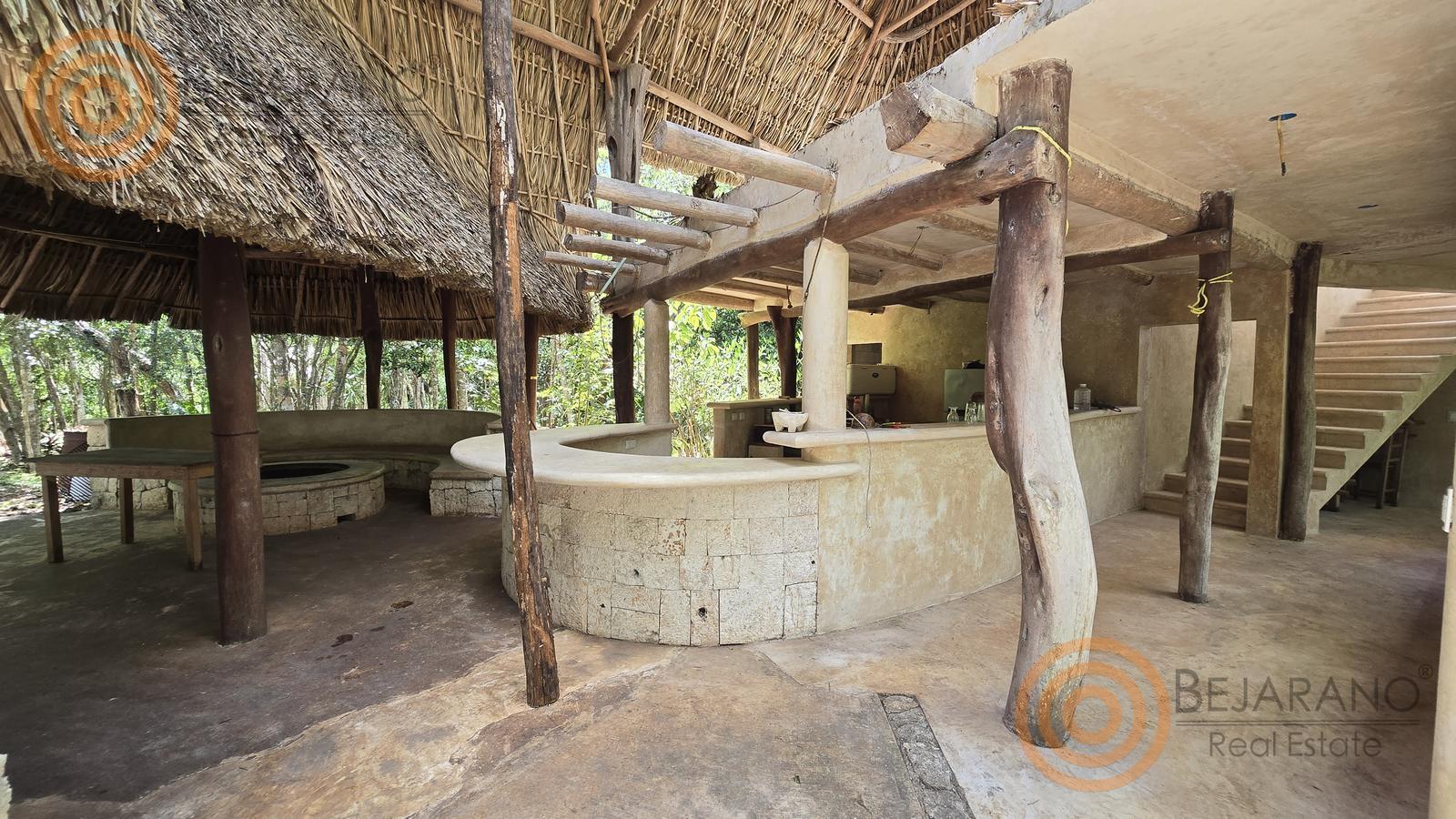 bre-rv-tixcalcupul-380-01 Interior de la palapa principal con barra de piedra y áreas sociales