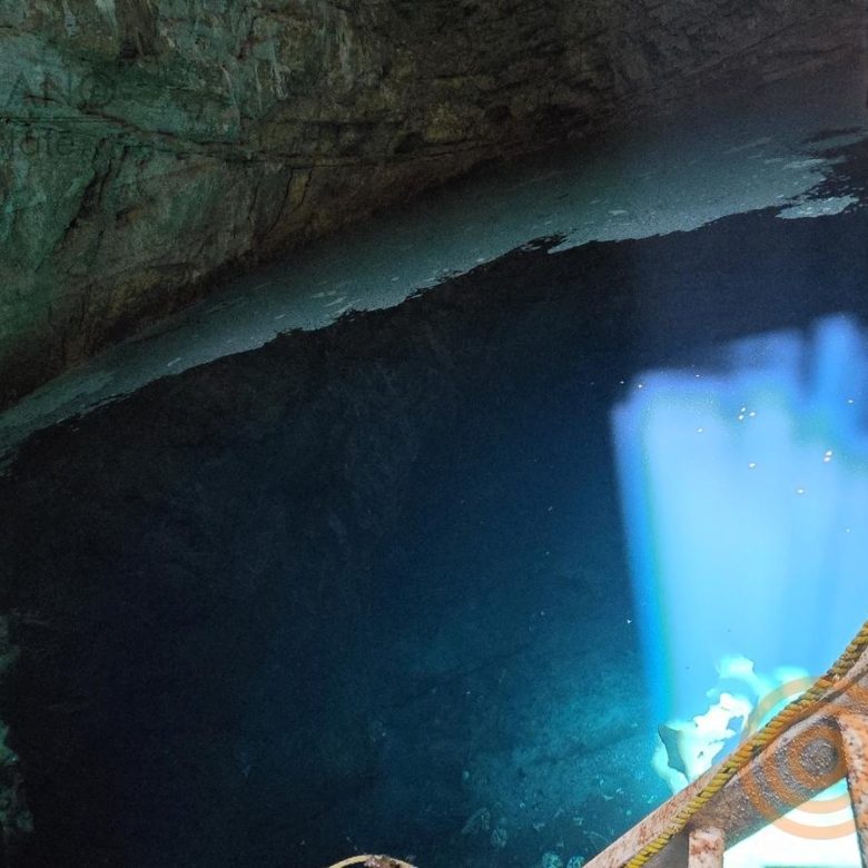 Agua turquesa del cenote con un haz de luz