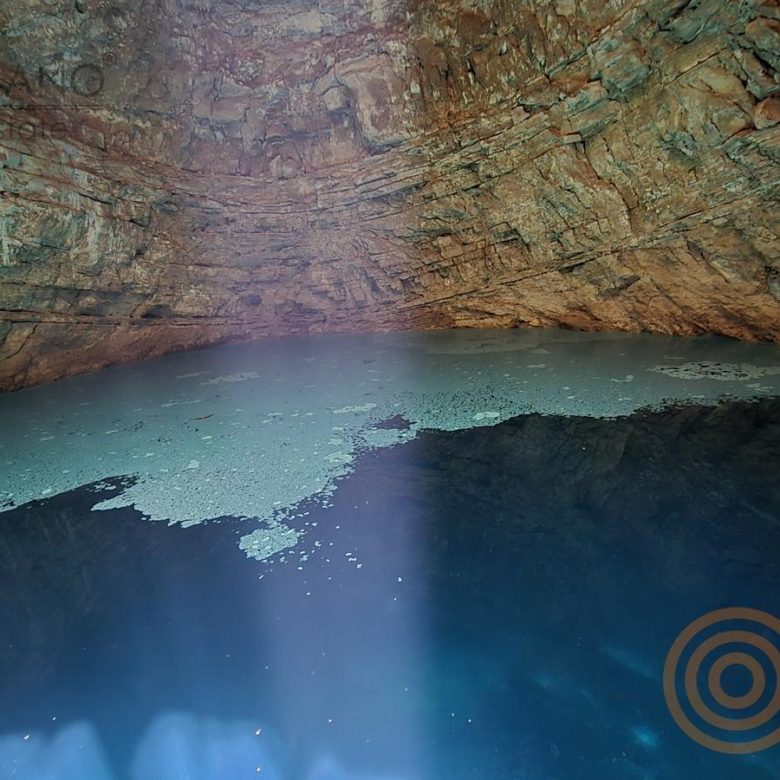Agua cristalina bajo la bóveda de roca del cenote