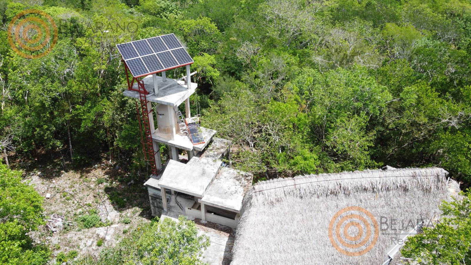 bre-rv-tixcalcupul-380-15 Panel solar y equipo de bombeo junto al cenote entre la vegetación