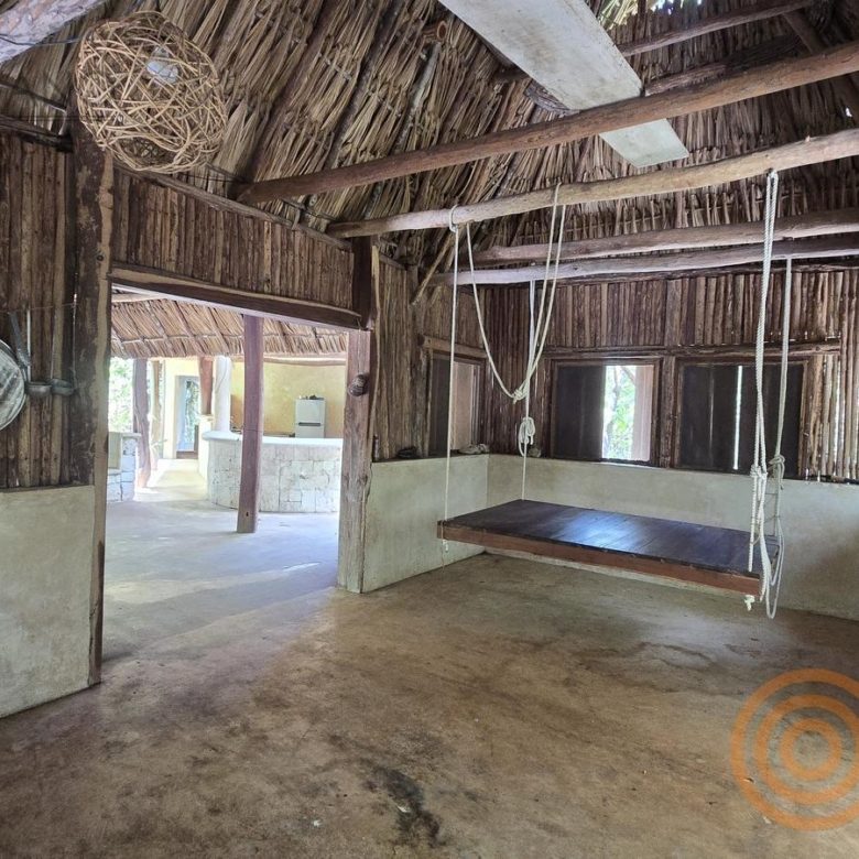 Interior de la palapa con área de descanso y columpio