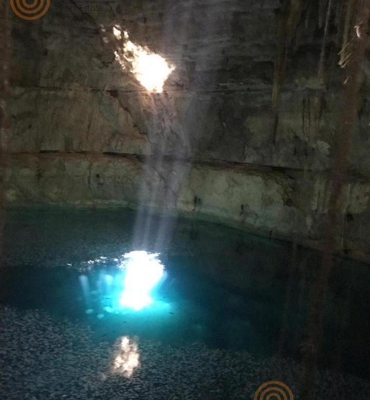 Haz de luz sobre el agua turquesa del cenote