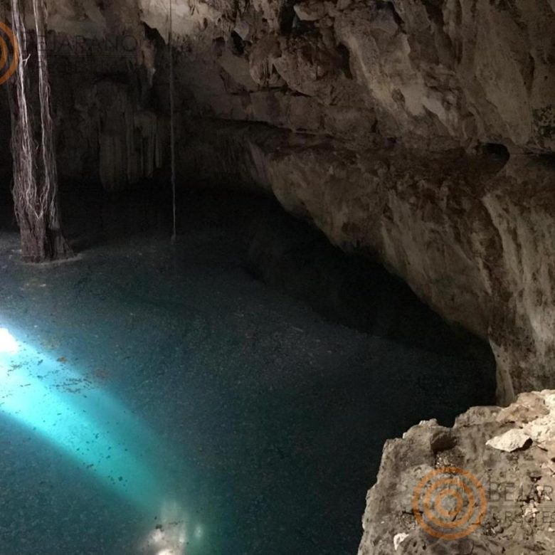 Cenote con agua cristalina bajo la bóveda de roca