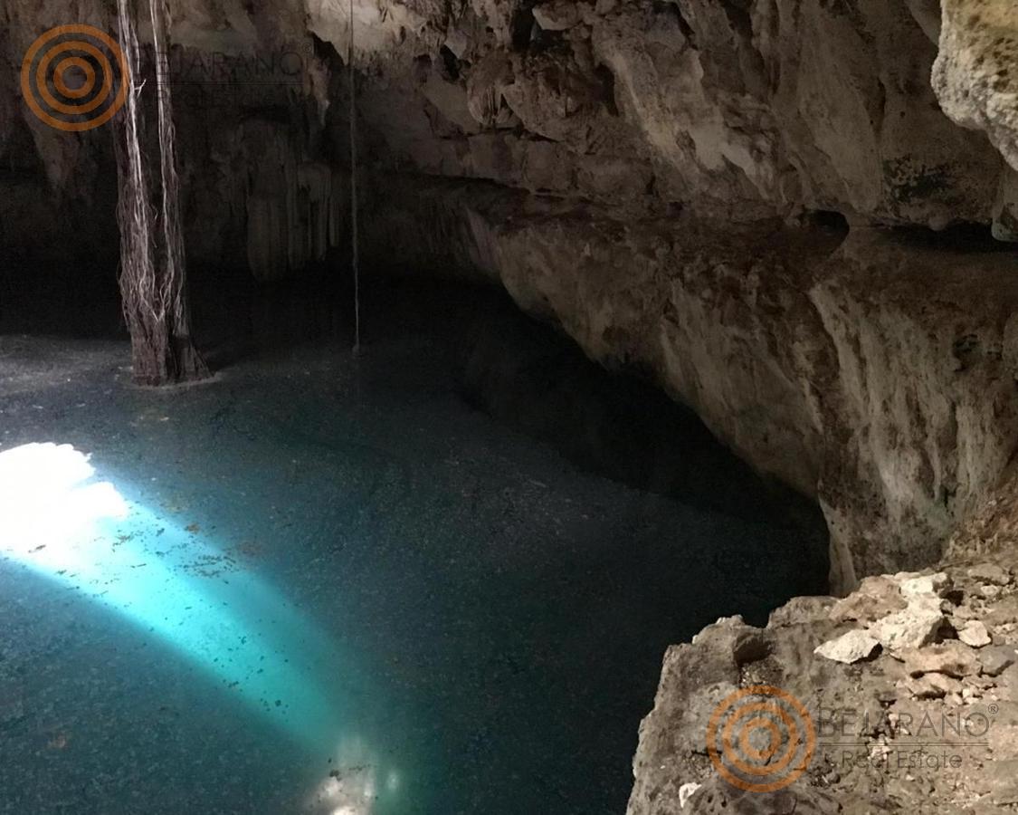 bre-tix-001-23 Cenote con agua cristalina bajo la bóveda de roca
