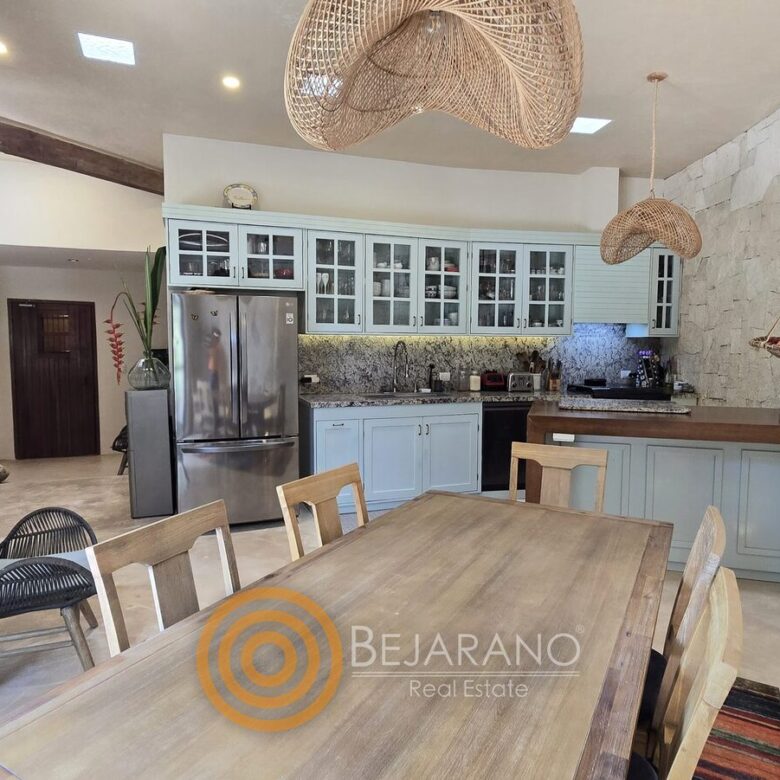 Cocina con comedor de madera y muro de piedra en Valladolid