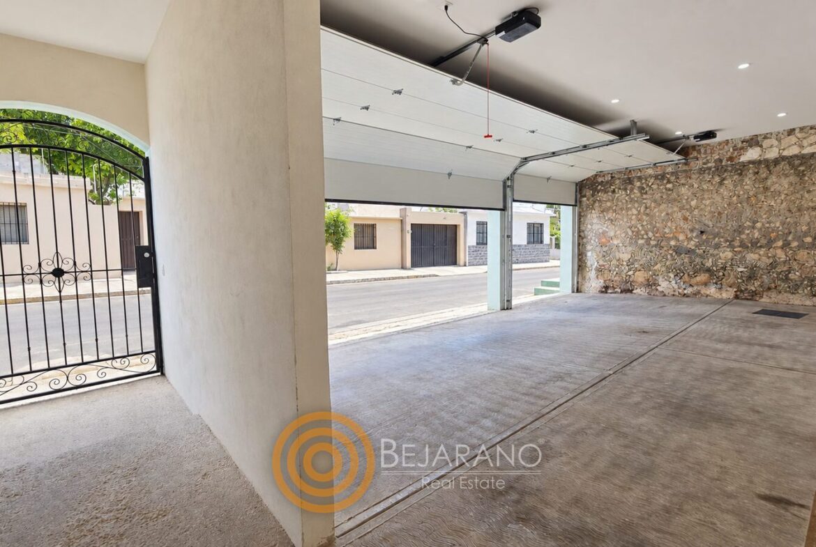 Cochera techada con portón eléctrico y reja de acceso peatonal