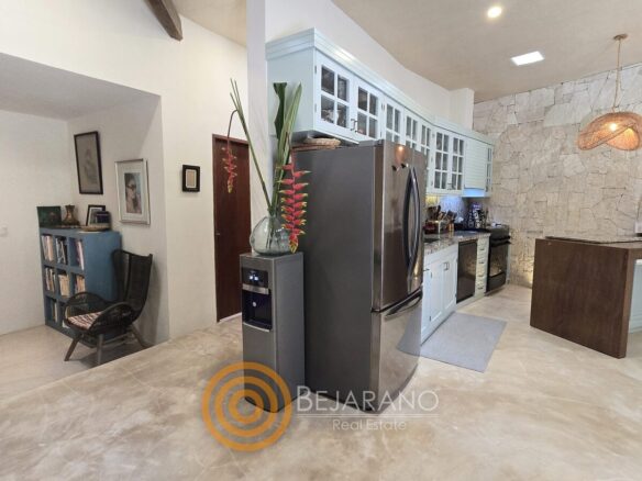 Cocina con refrigerador de acero inoxidable y barra de madera