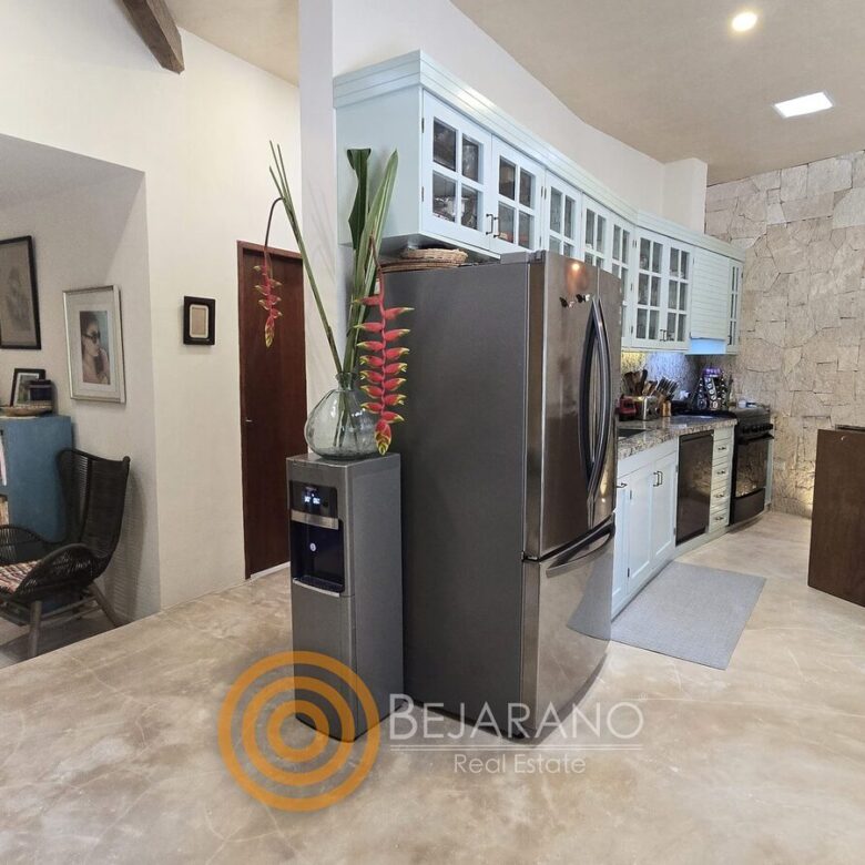 Cocina con refrigerador de acero inoxidable y barra de madera
