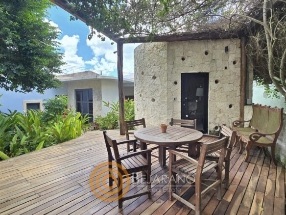 Deck de madera con comedor exterior bajo pérgola