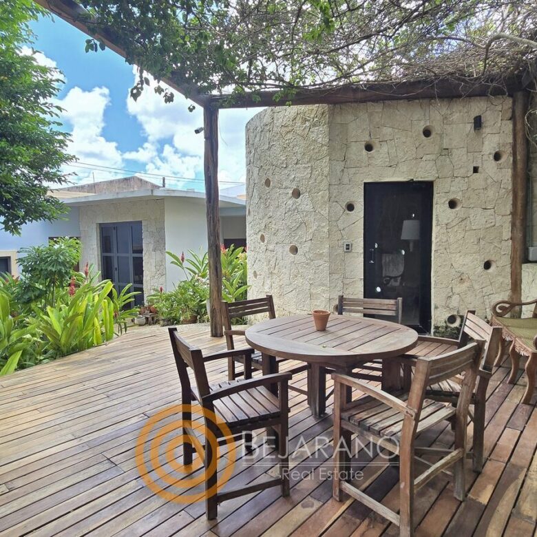 Deck de madera con comedor exterior bajo pérgola
