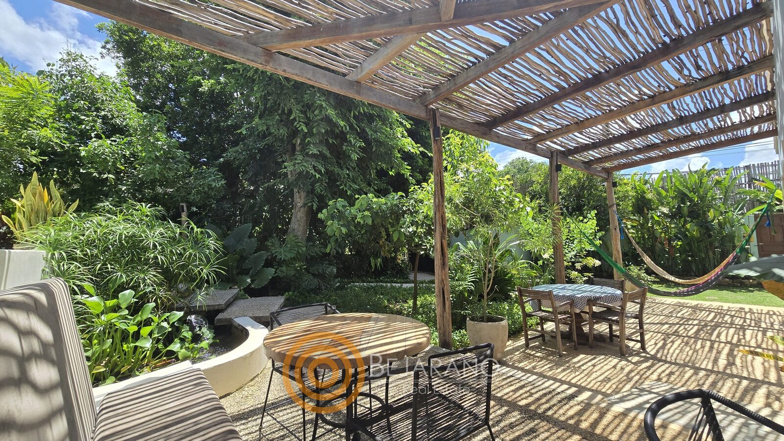 bre-cv-petanka-25 Terraza con mesas de madera frente al jardín tropical