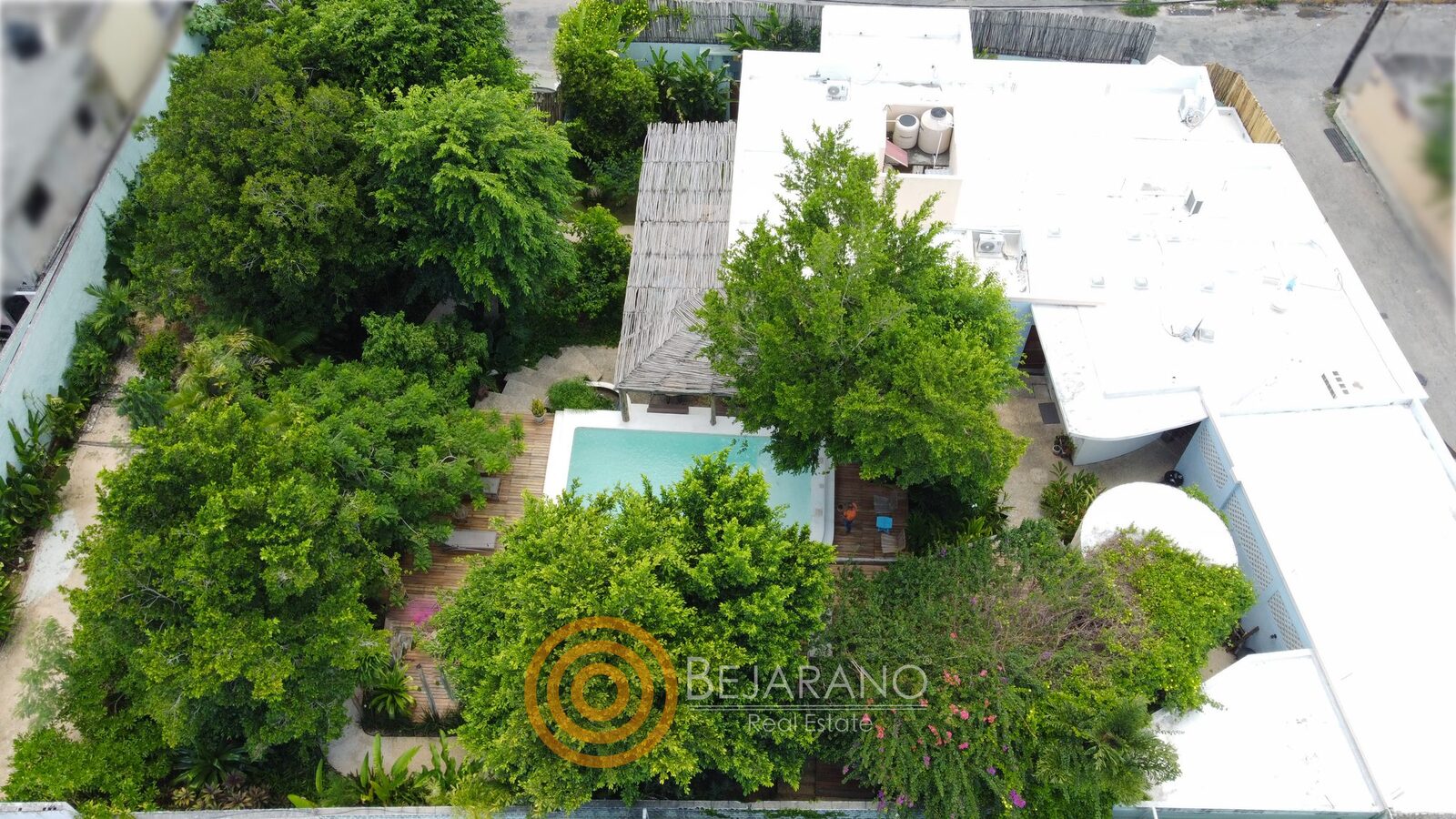 bre-cv-petanka-30 Toma de dron del jardín arbolado, la alberca y las azoteas