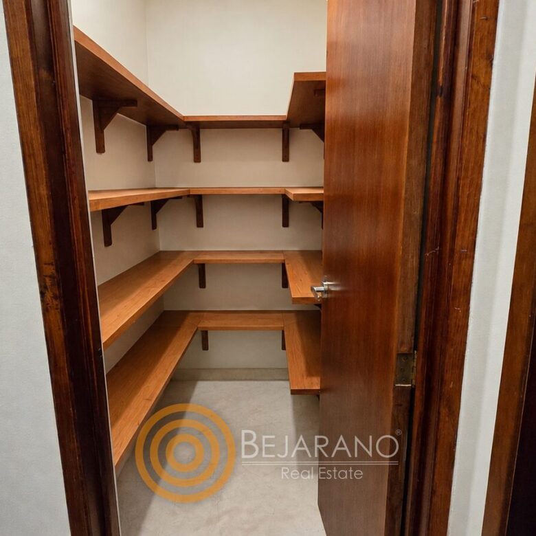Despensa con repisas de madera junto a la cocina